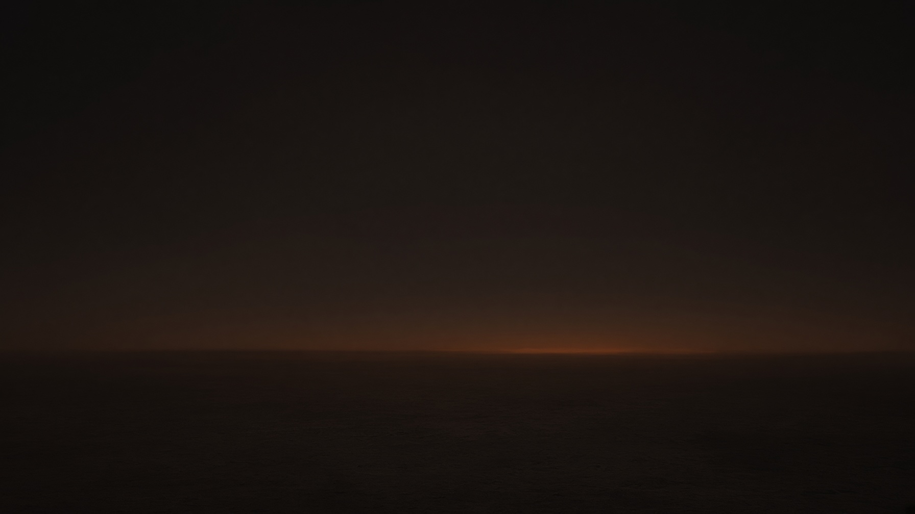 A nearly dark sky with a faint warm horizon.